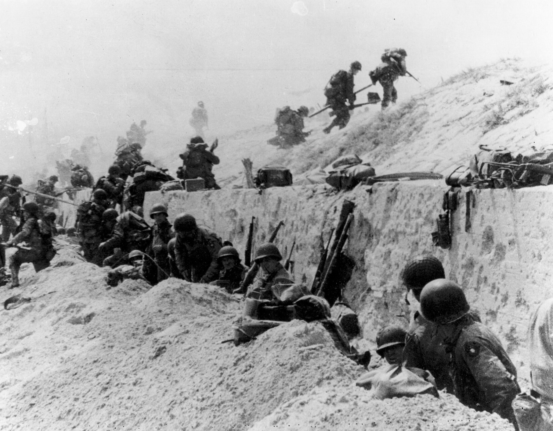 U.S. soldiers of the 8th Infantry, 4th Infantry Division advance over the sea-wall at Utah. 